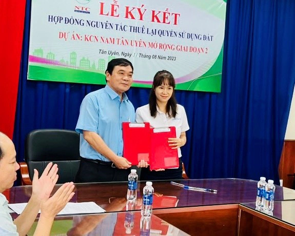 Bà Tạ Thị Bình, Tổng giám đốc Công ty Nam Trang (công ty thành viên của tập đoàn Tập đoàn Quang Minh - Nam Sơn) thực hiện nghi lễ ký kết với ông Hà Trọng Bình, thành viên HĐQT, Tổng Giám đốc Công ty cổ phần KCN Nam Tân Uyên